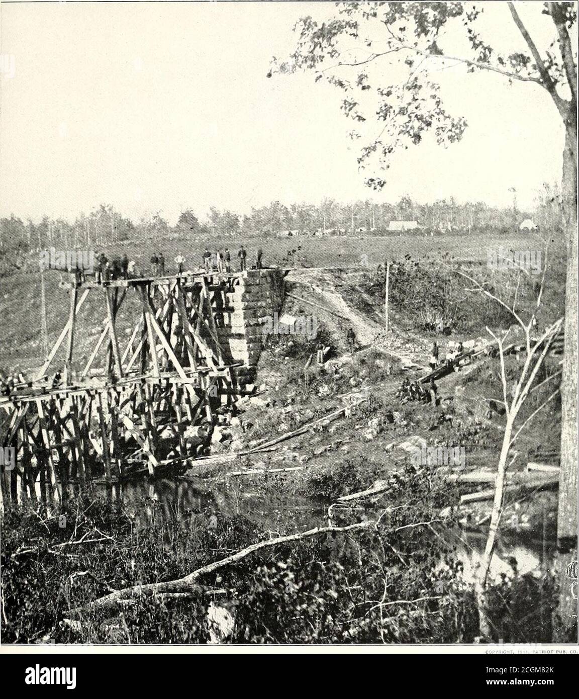 . The photographic history of the Civil War : in ten volumes . REPAIRING CONFEDERATE DAMAGE The busy Federal engineers are rebuilding the railroad bridge across Cedar Run. near Catletts Station, destroyed by the Confederateson the previous day, October 13th, when they fell back before the Army of the Potomac under General Meade. The fall of 1863 wasa period of small cavalry battles. On September 10th the Army of the Potomac crossed the Rappahannock and took position near(ulpcper Court House. During the next few weeks the cavalry was actively engaged in reconnoitering duty. On October 10th Gene Stock Photo