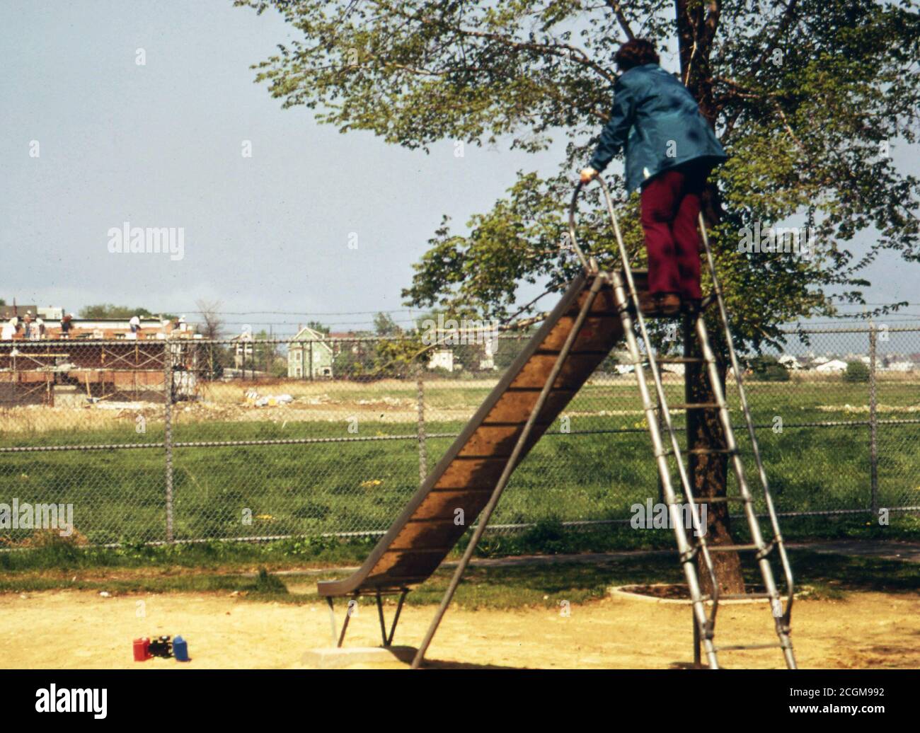 1973 Boston - Child Looks Over Construction of Airlines Food Services Building from Top of Slide. Playground Is at Runway End of Neptune Road Stock Photo