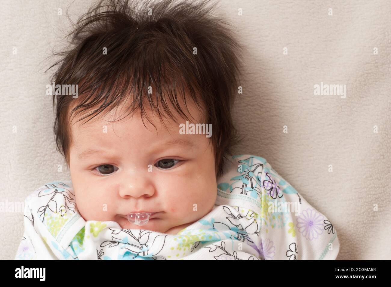 closeup of newborn baby girl one month old 'bubbling' playing with spit Stock Photo