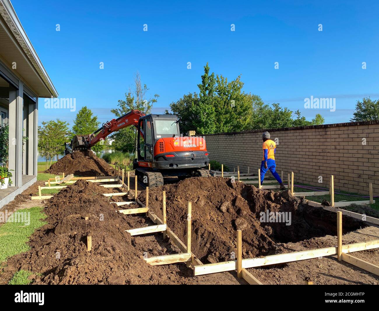 Orlando, FL/USA 5/21/20 A backhoe digging a hole for a pool behind a