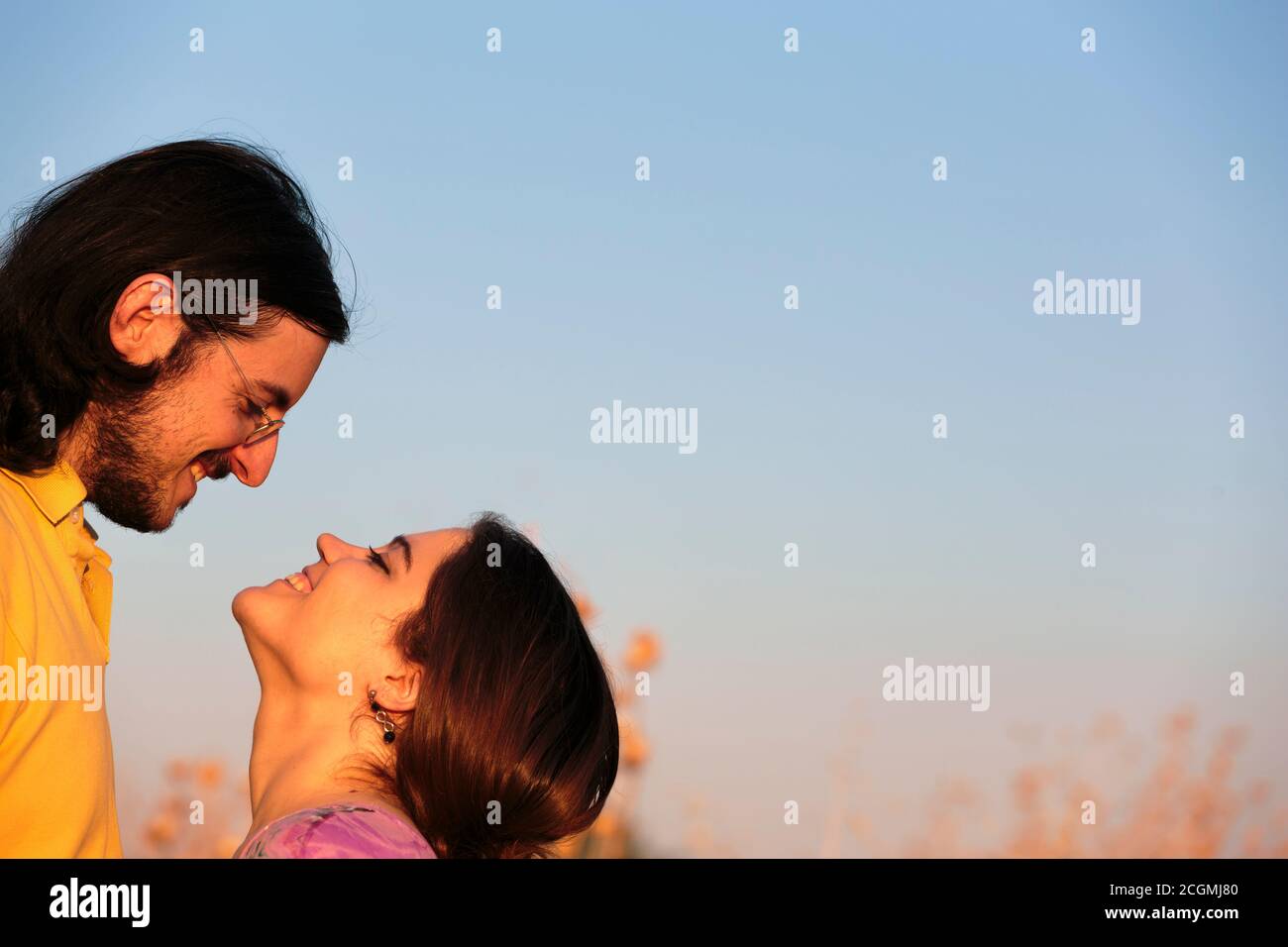 Sweet couple about to kiss on light blue gray sky background Stock Photo