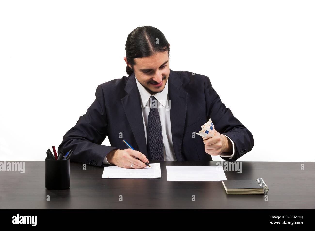 Greedy ambitious man working at his desk Stock Photo