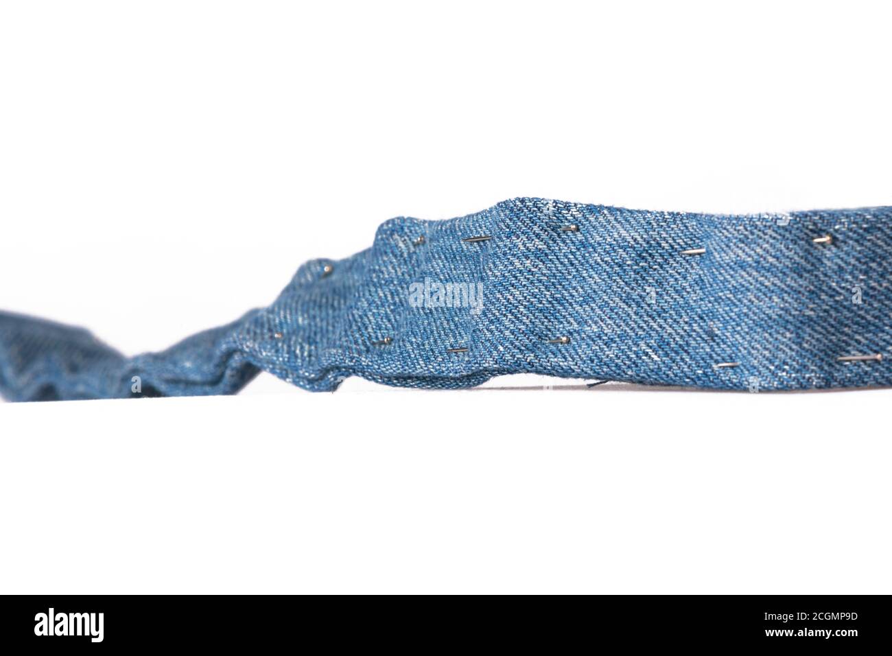 Strip of blue cotton denim fabric with tacking Stock Photo