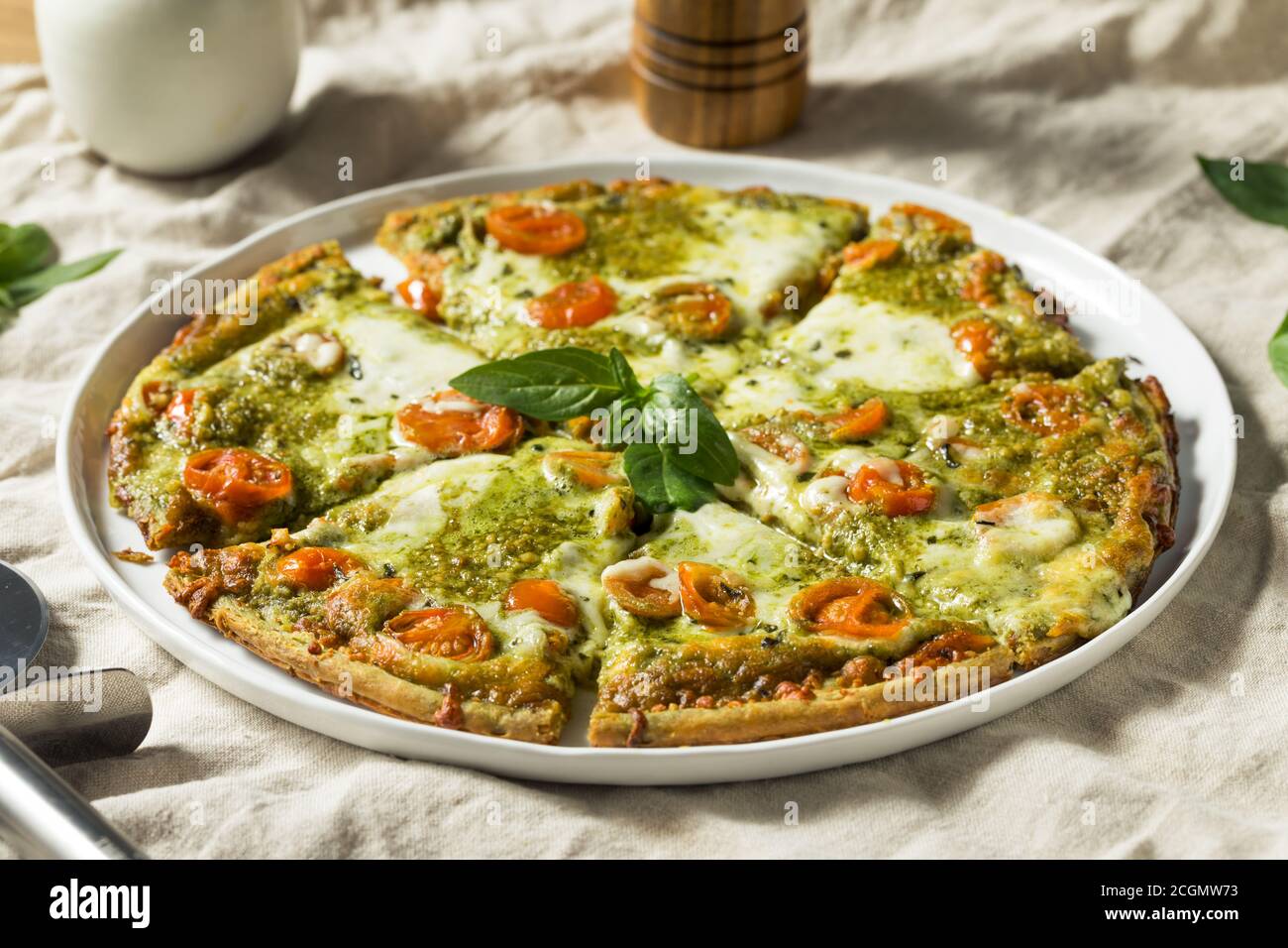 Homemade Green Pesto Pizza with Mozzarella and Tomatoes Stock Photo