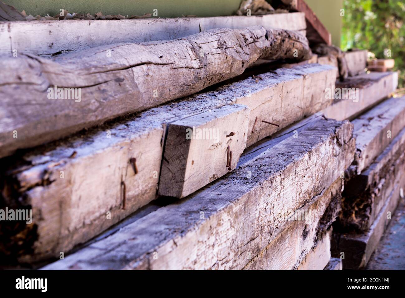 Old rotten wood beams stored outdoors unprotected Stock Photo
