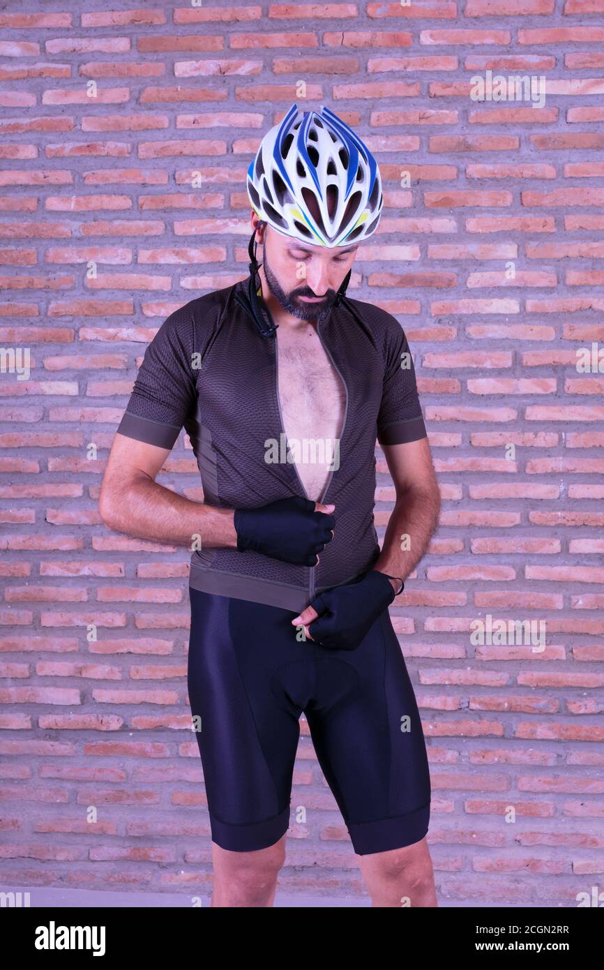 Young male cyclist dressing up looking down Stock Photo