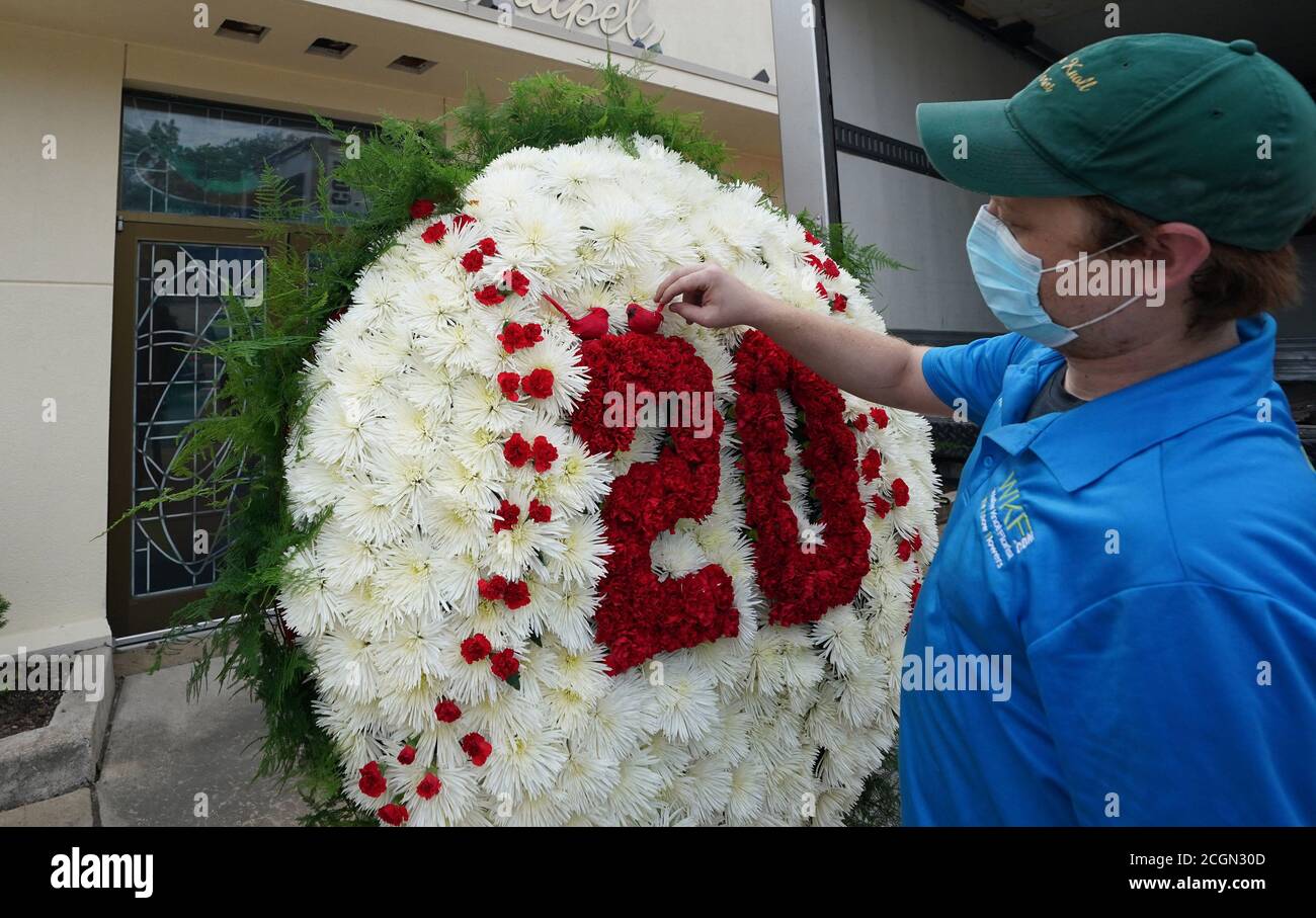 Walter Knoll Florist worker Kevin Cujar checks the Cardinals attached to a large baseball made