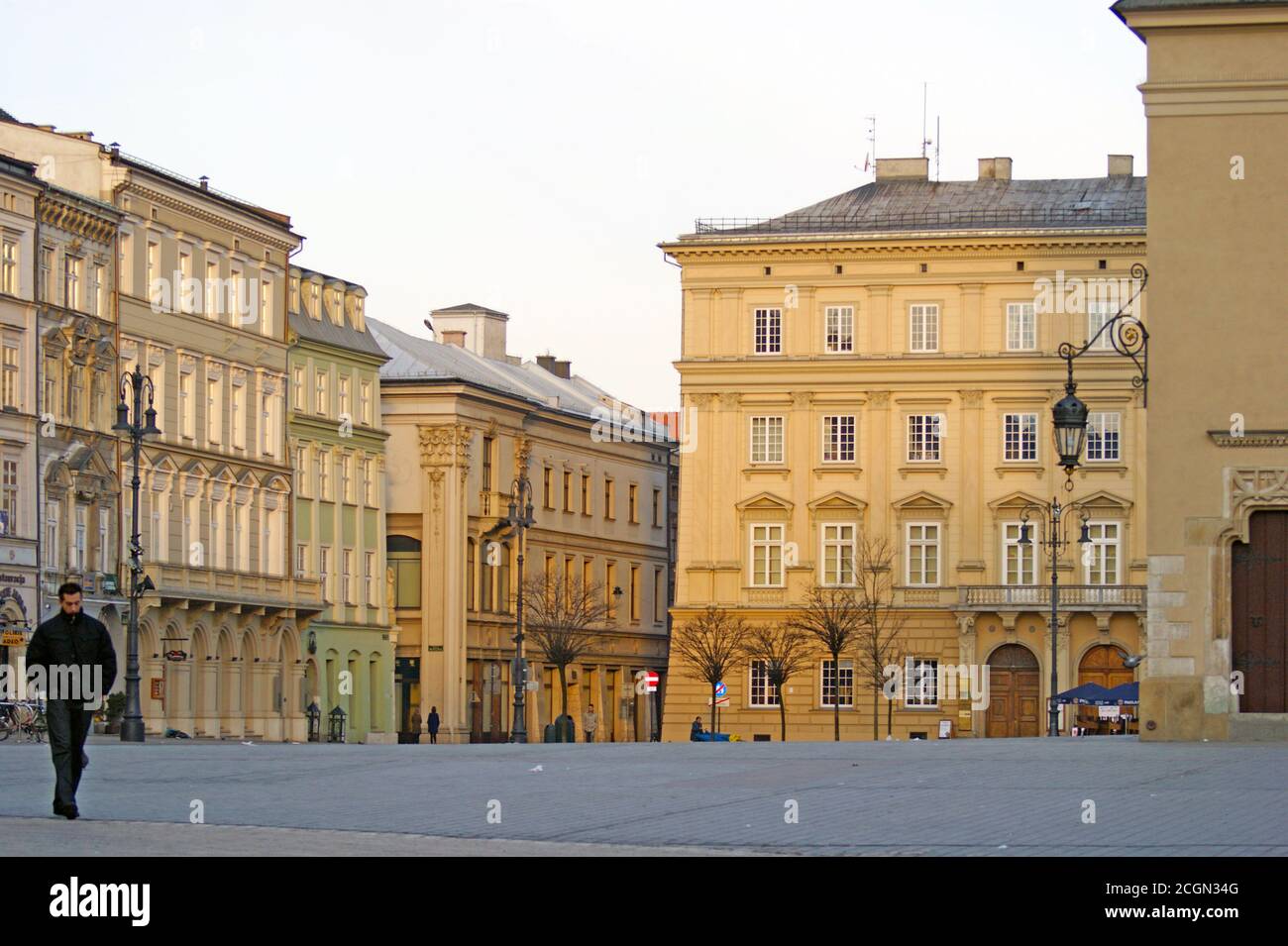 A solitary man walks through the Krakow Old Town Main Market square in the early morning in Krakow, Poland on January 6, 2010. Stock Photo