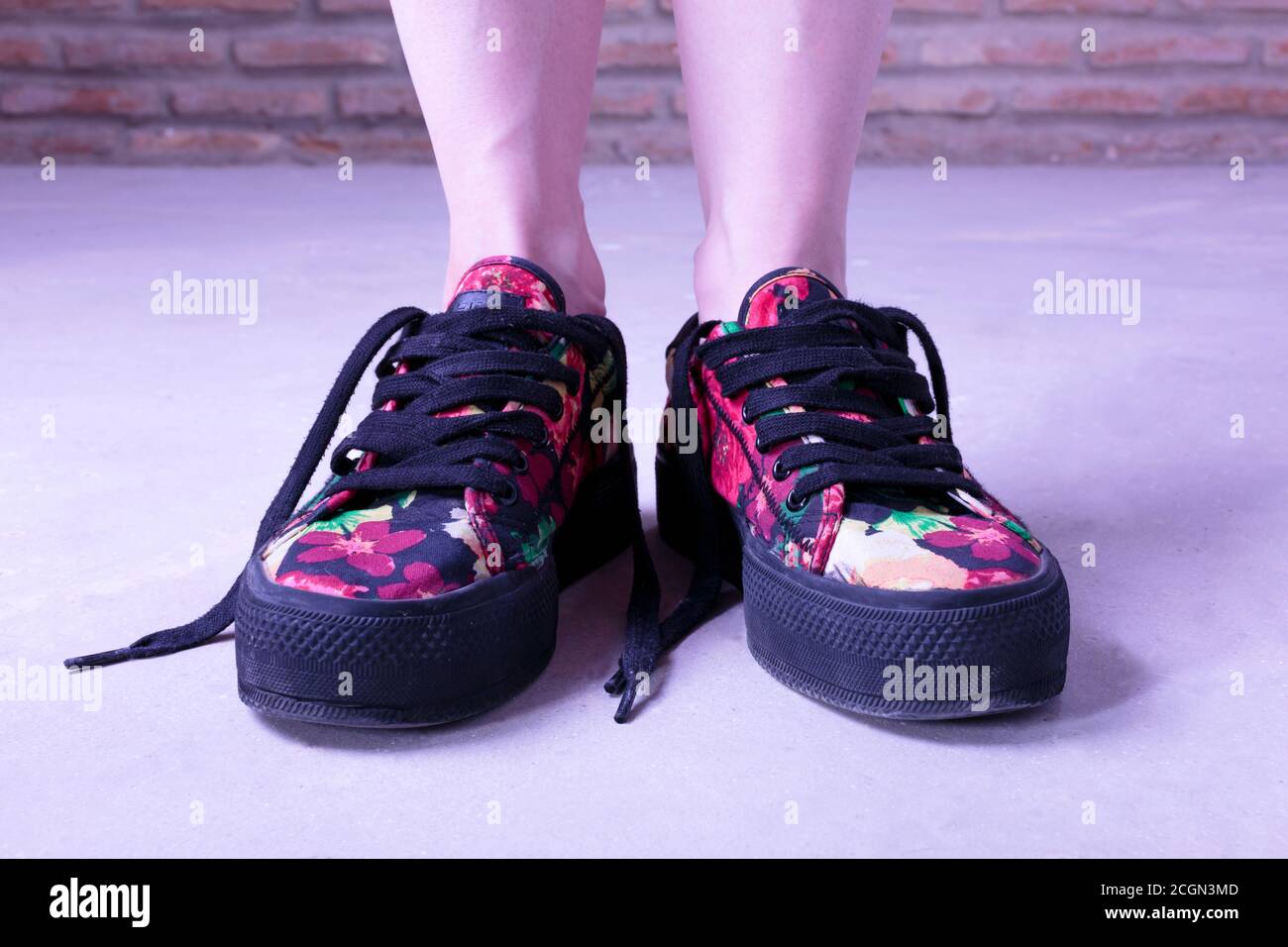 Vintage looking flowery shoes worn by a young woman Stock Photo