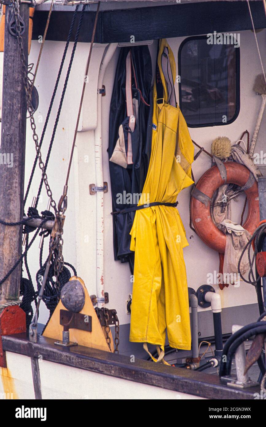 Foul weather gear and life ring aboard fishing boat moored at Fisherman’s Terminal, Port of Seattle, Washington USA Stock Photo