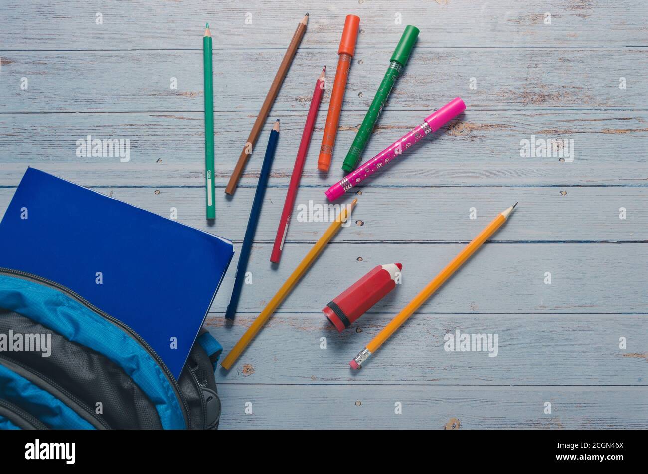 Back To Scholl crayons and Backpack in Blue Background Stock Photo - Alamy
