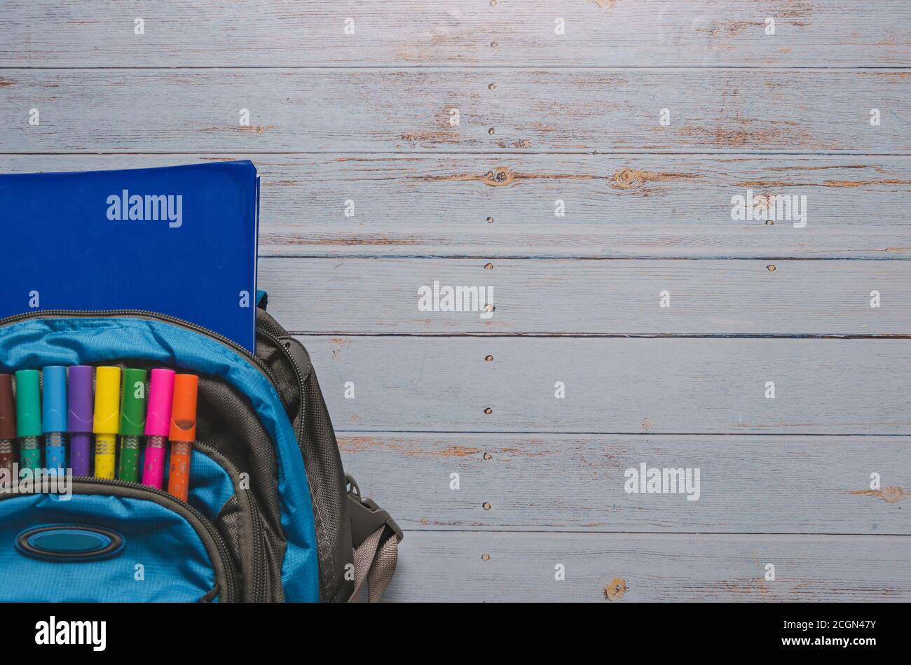 Back To Scholl crayons and Backpack in Blue Background Stock Photo - Alamy