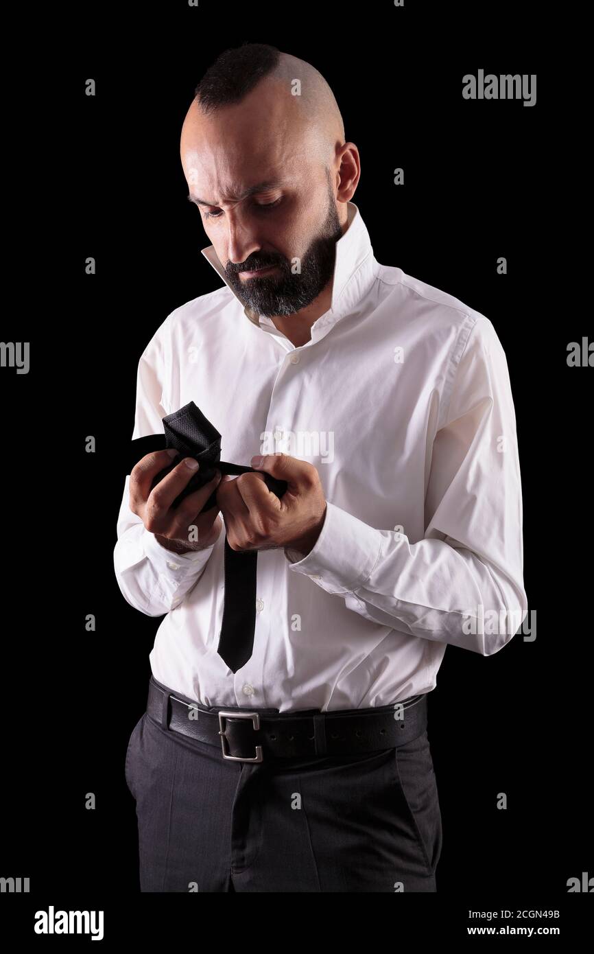 Young hispanic man dressing up irritated because of his tie Stock Photo