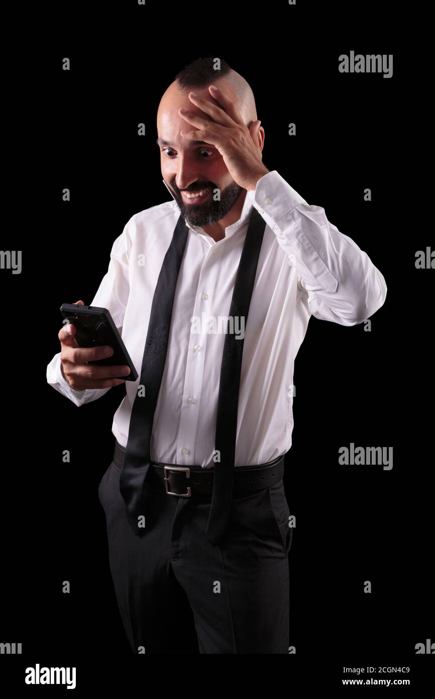 Surprised hispanic man reading unbelievable news on his smartphone Stock Photo