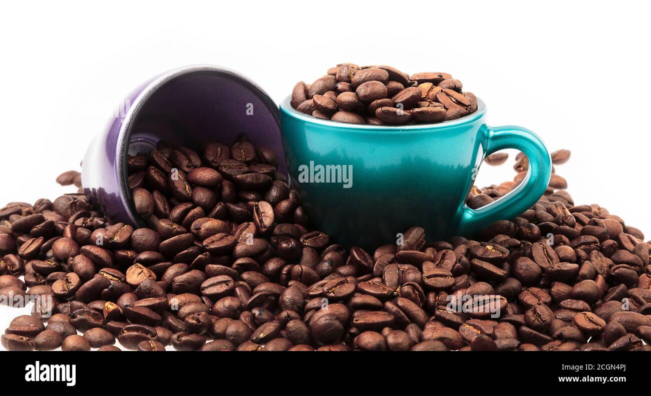 Cups of coffee with beans in and spilled around isolated on white Stock Photo