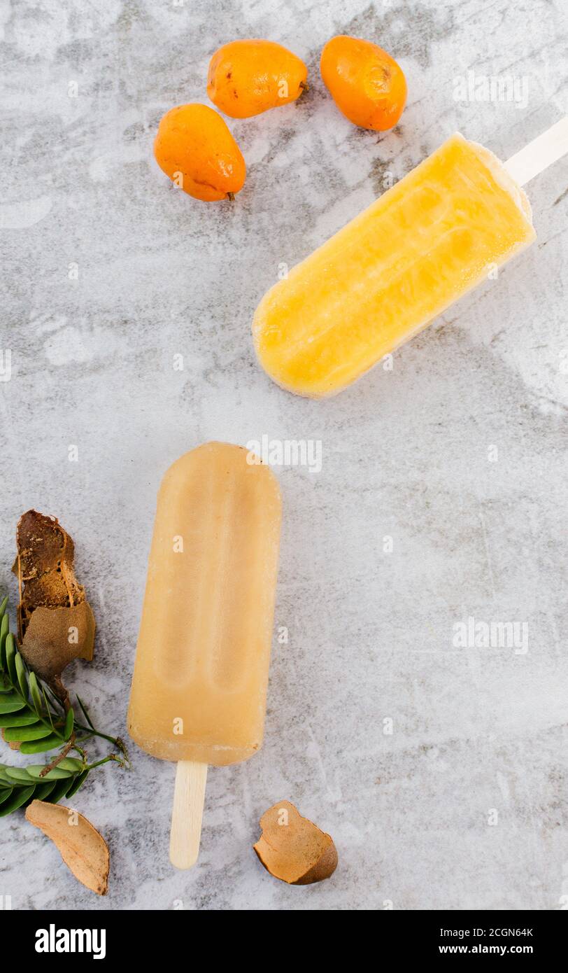 Tamarind and Jobito Fruit Popsicle with Tamarind and Jobito Fruit in Gray Background Rustic Stock Photo
