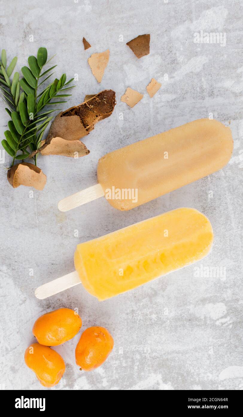 Tamarind and Jobito Fruit Popsicle with Tamarind and Jobito Fruit in Gray Background Rustic Stock Photo