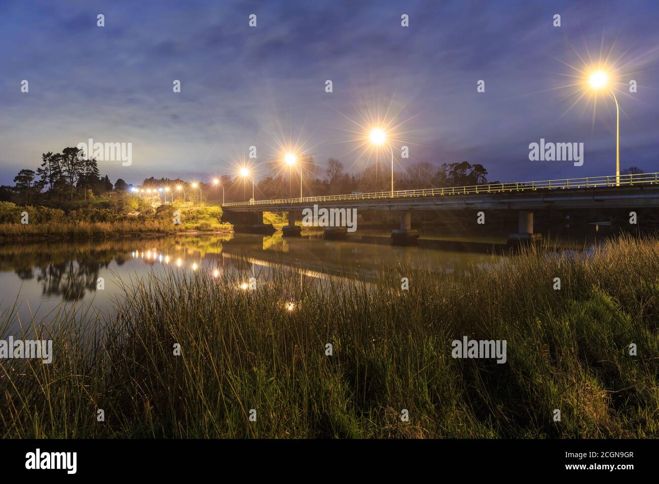 A road bridge over a river in the countryside. Photographed at night with bright streetlights Stock Photo