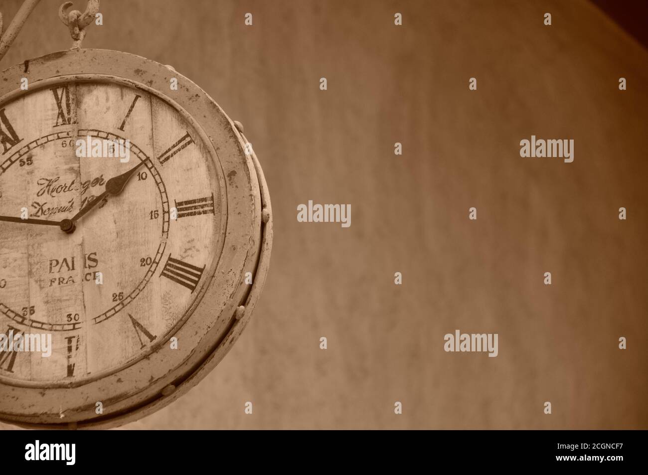 Vintage appeal roman numeral clock face hanging from outside wall ...