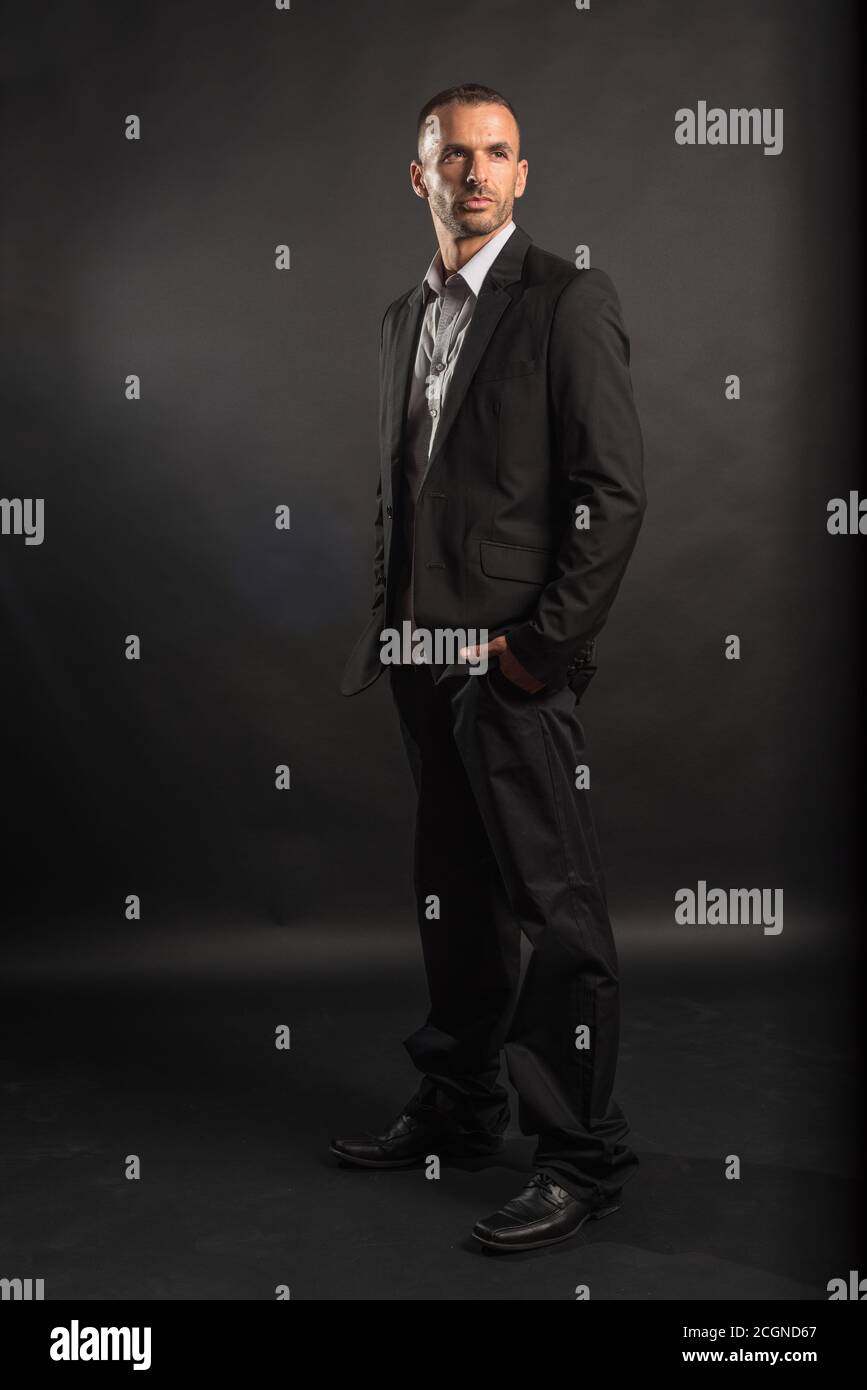 Handsome man in suit. Full body. Black background. Stock Photo
