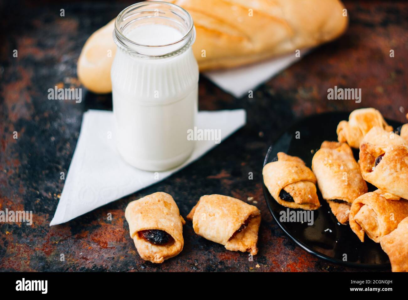 Nice breakfast - milk with croissants on black rustic surface Stock Photo