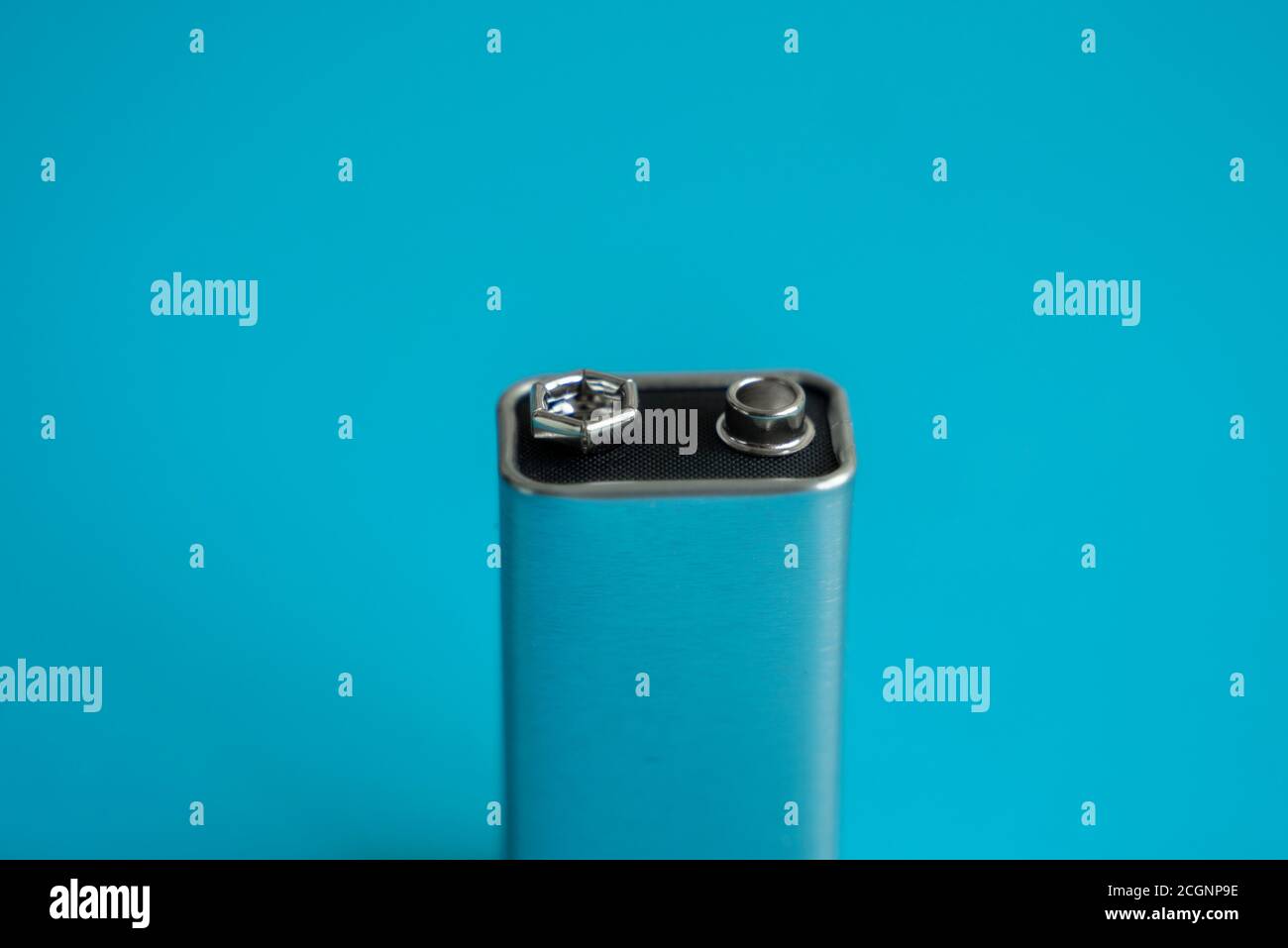 High voltage battery on a blue background. Silver Volt battery. 9V
