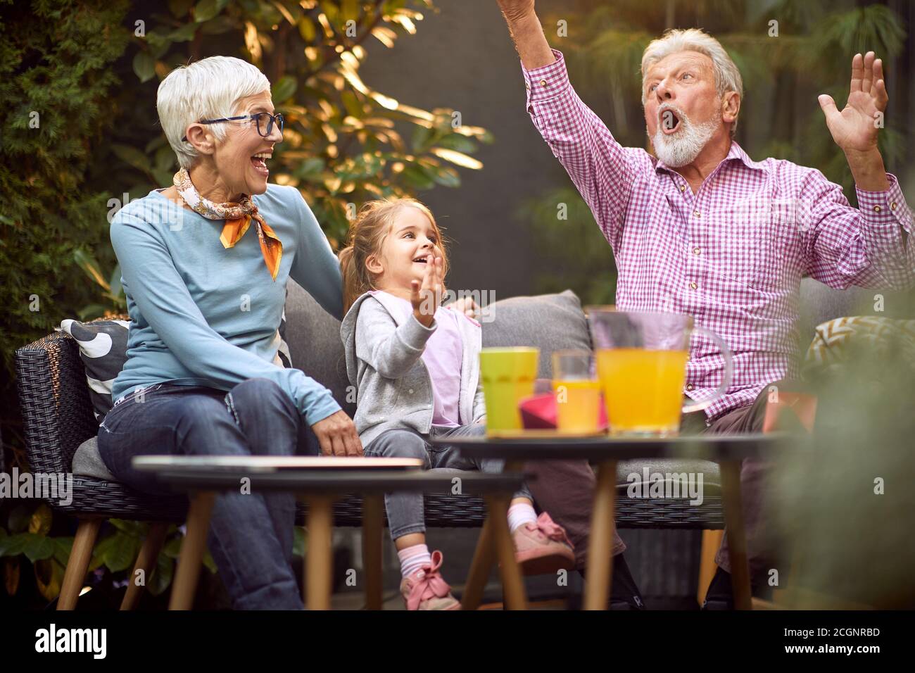 caucasian grandpa amusing granddaughter with her grandma Stock Photo