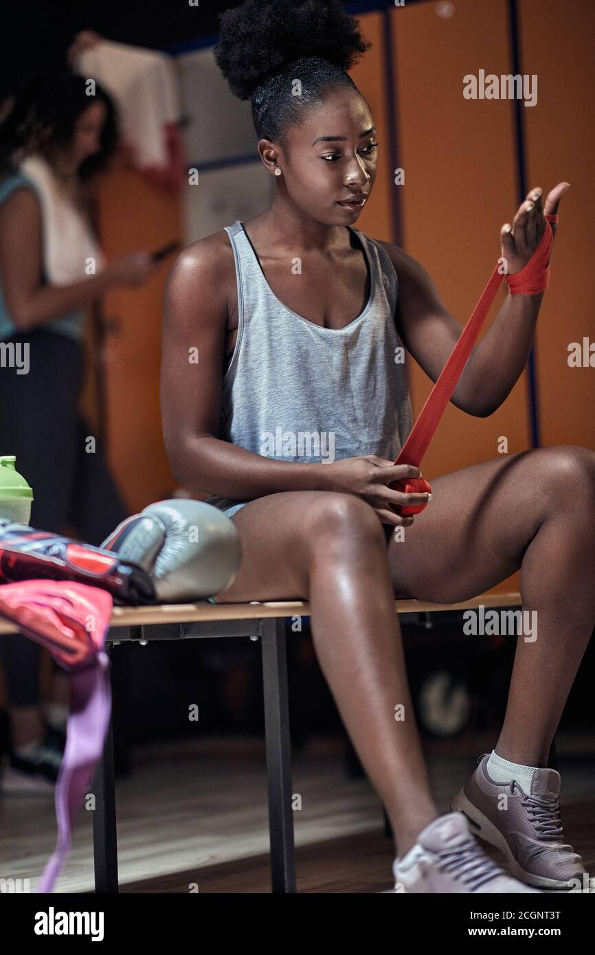 Female boxer in a locker room preparing for a training Stock Photo