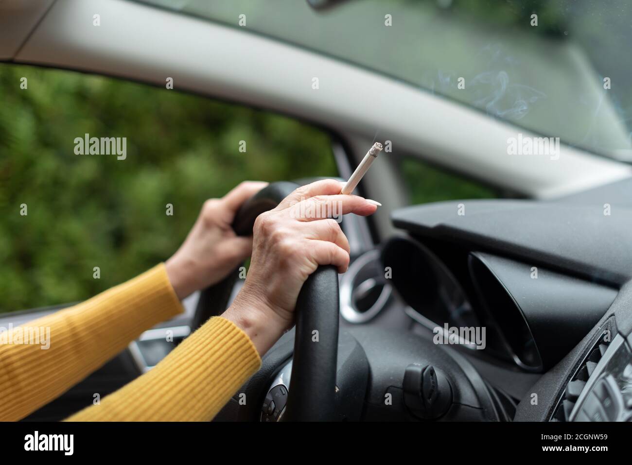 Woman smoking a cigarette while driving Stock Photo Alamy