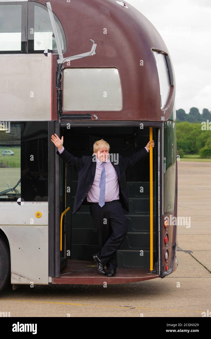 Boris Johnson Mayor of London revealing to the press a prototype of the New Bus for London which is undergoing trials at the Millbrook Proving Ground vehicle testing centre located at Millbrook, Bedfordshire. The bus late became know as New Routemaster and was nick named the Boris Bus.   The New Bus for London, is a hybrid diesel-electric double-decker bus operated in London, Designed by Heatherwick Studio and manufactured by Wrightbus, it is notable for featuring a 'hop-on hop-off' rear open platform similar to the original Routemaster bus design but updated to meet requirements for modern bu Stock Photo