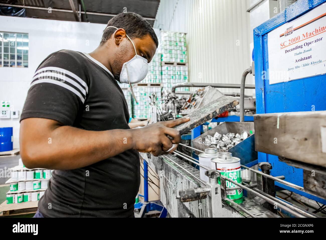 Johannesburg, South Africa - October 19, 2012: Diverse people working on an assembly line in a glue factory Stock Photo