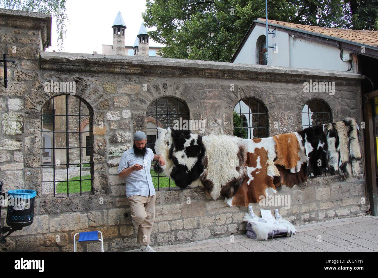 Sarajevo, Bosnia and Herzegovina - July 3rd 2018: A muslim street seller, selling animal skins outside the Gazi Husrev-beg's Madrasa Mosque, in the Ba Stock Photo