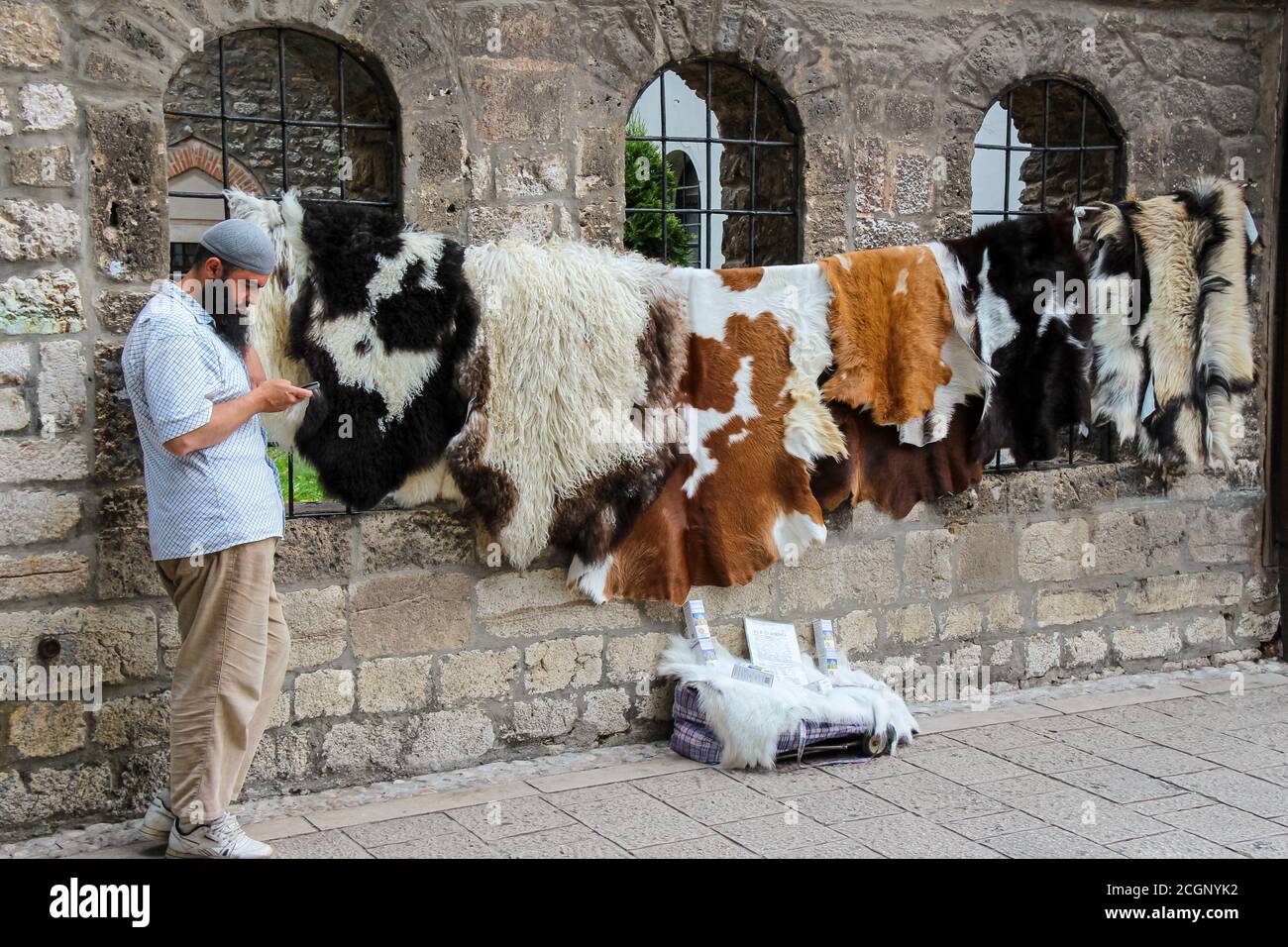 Sarajevo, Bosnia and Herzegovina - July 3rd 2018: A muslim street seller, selling animal skins outside the Gazi Husrev-beg's Madrasa Mosque, in the Ba Stock Photo