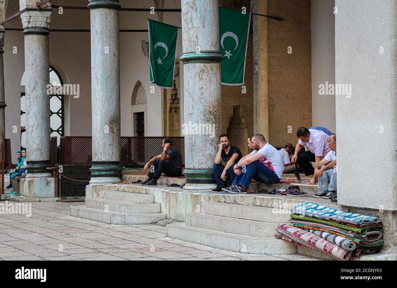 Sarajevo, Bosnia and Herzegovina - July 3rd 2018: Muslims sitting outside Gazi Husrev-beg's Madrasa Mosque, in the Bascarsija neighbourhood, old town Stock Photo