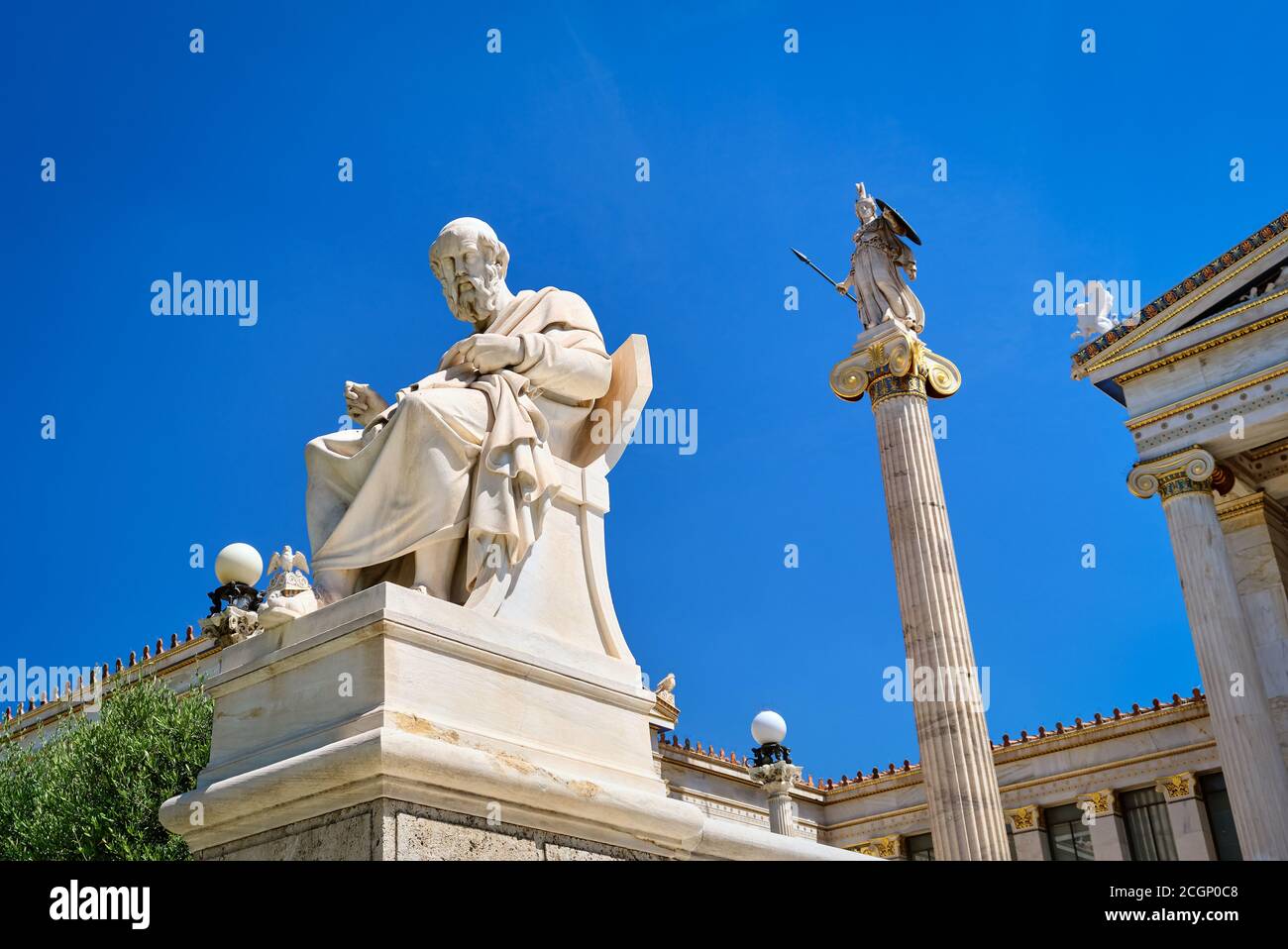 Marble statue of Plato, great ancient Greek philosopher, seated in chair and column or pillar with statue of Athena, ancient Greek goddess, patron of Stock Photo