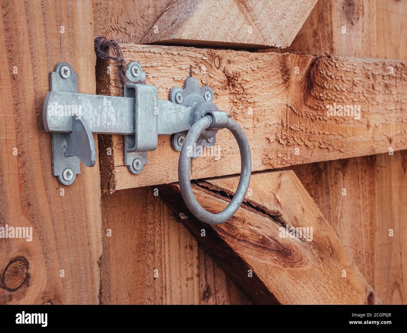 A silver bolt securing a wooden gate in a garden Stock Photo