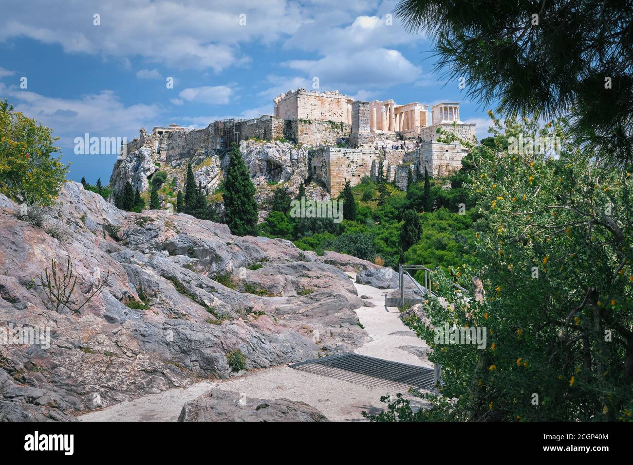 View of Acropolis hill from Areopagus hill on summer day with great clouds in blue sky, Athens, Greece. UNESCO world heritage. Propylaea, Parthenon. Stock Photo