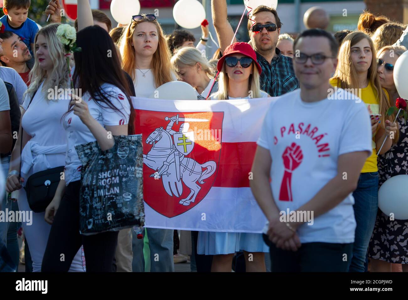 People with a red and white Belarusian flag at a rally. Stock Photo