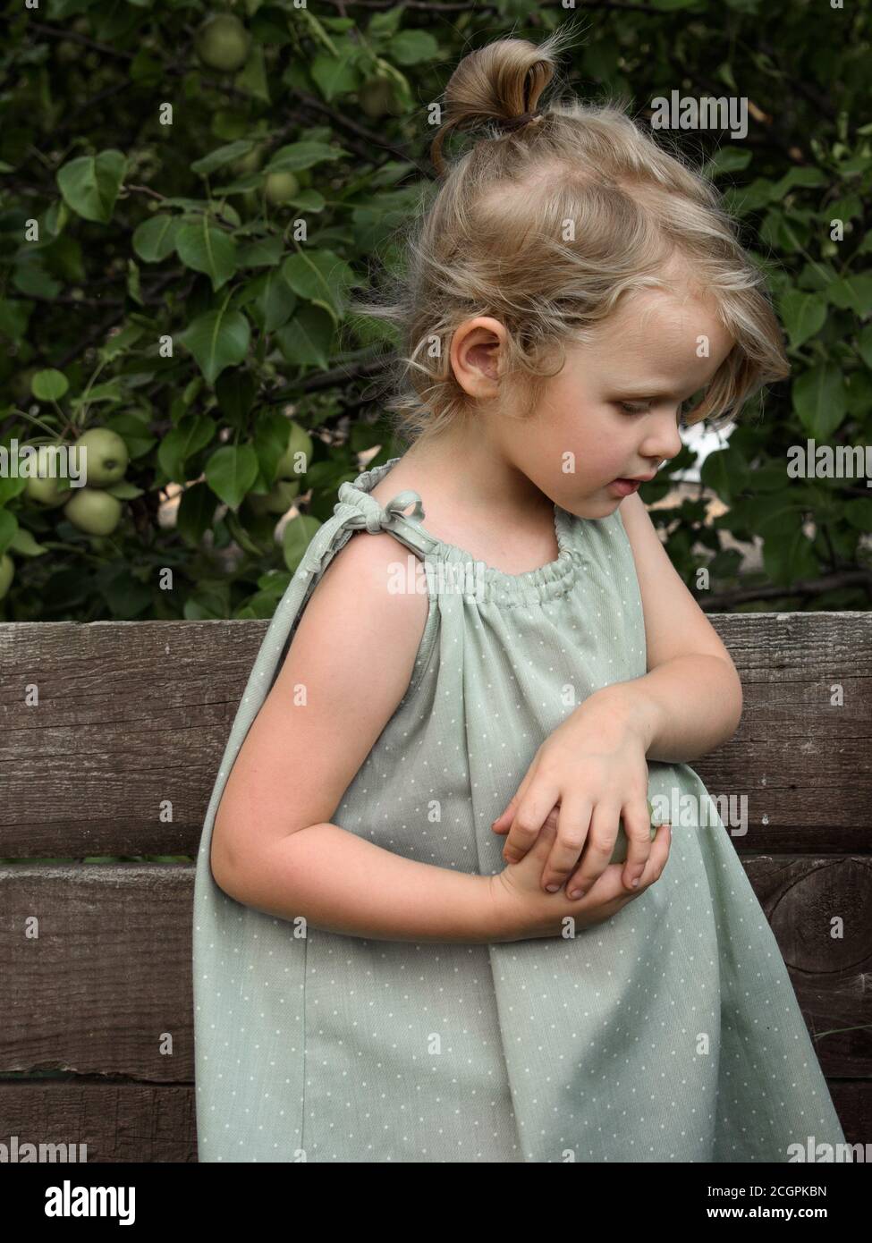 Little girl looks down thoughtfully. Side view Stock Photo - Alamy
