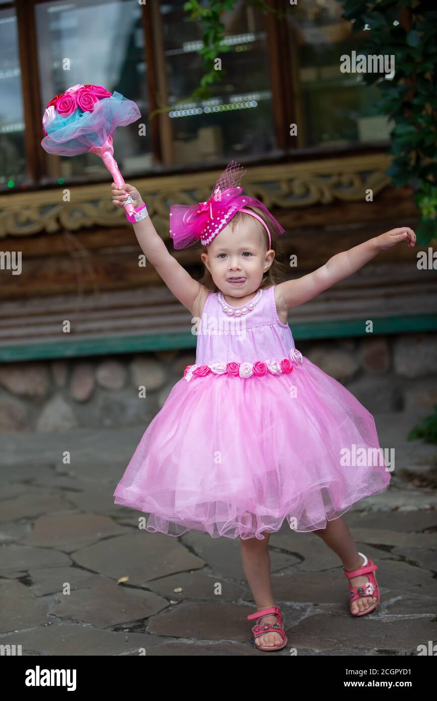 Beautiful little girl in an elegant dress with a bouquet of flowers ...
