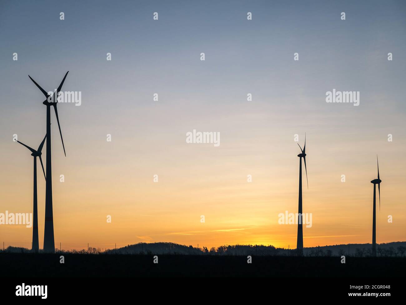 Silhouettes of wind turbines from a sunset colored sky Stock Photo - Alamy