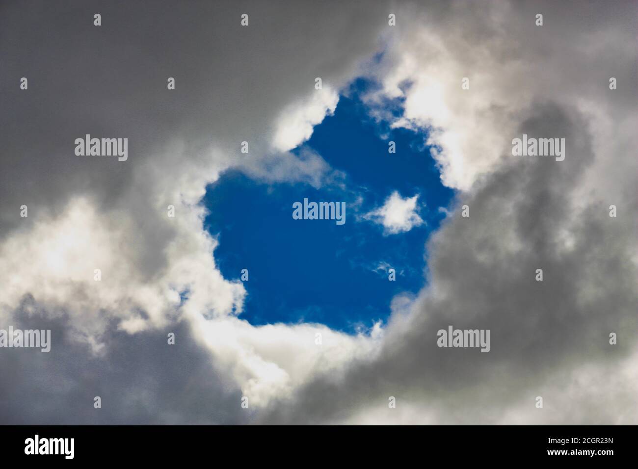 blue hole peeks through the clouds Stock Photo