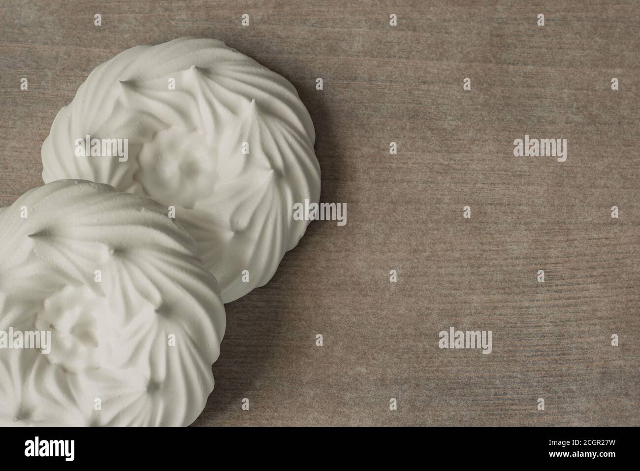 couple of meringue nests on parchment paper. top view Stock Photo Alamy