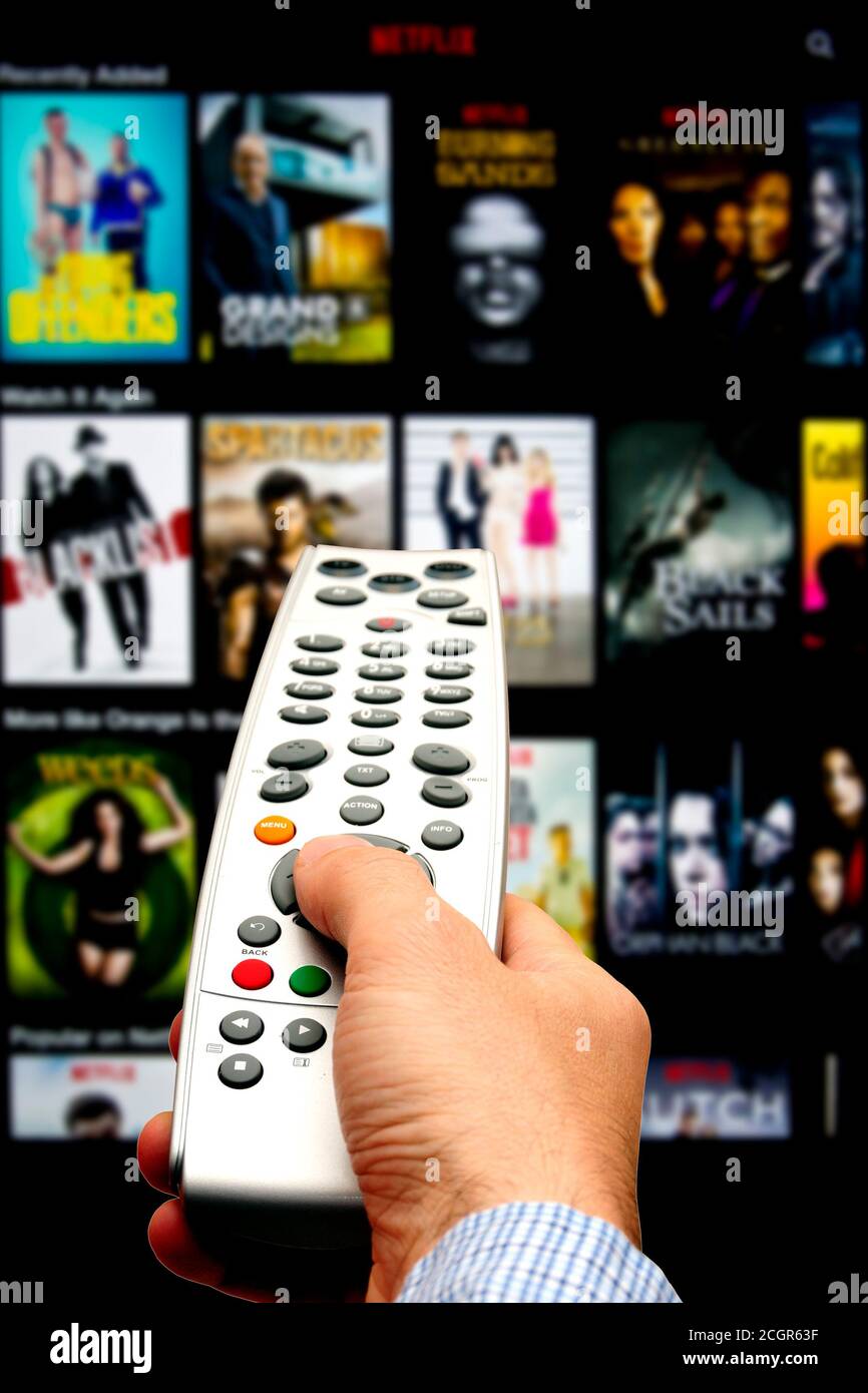 hand holding remote and choosing a program to watch on netflix Stock Photo