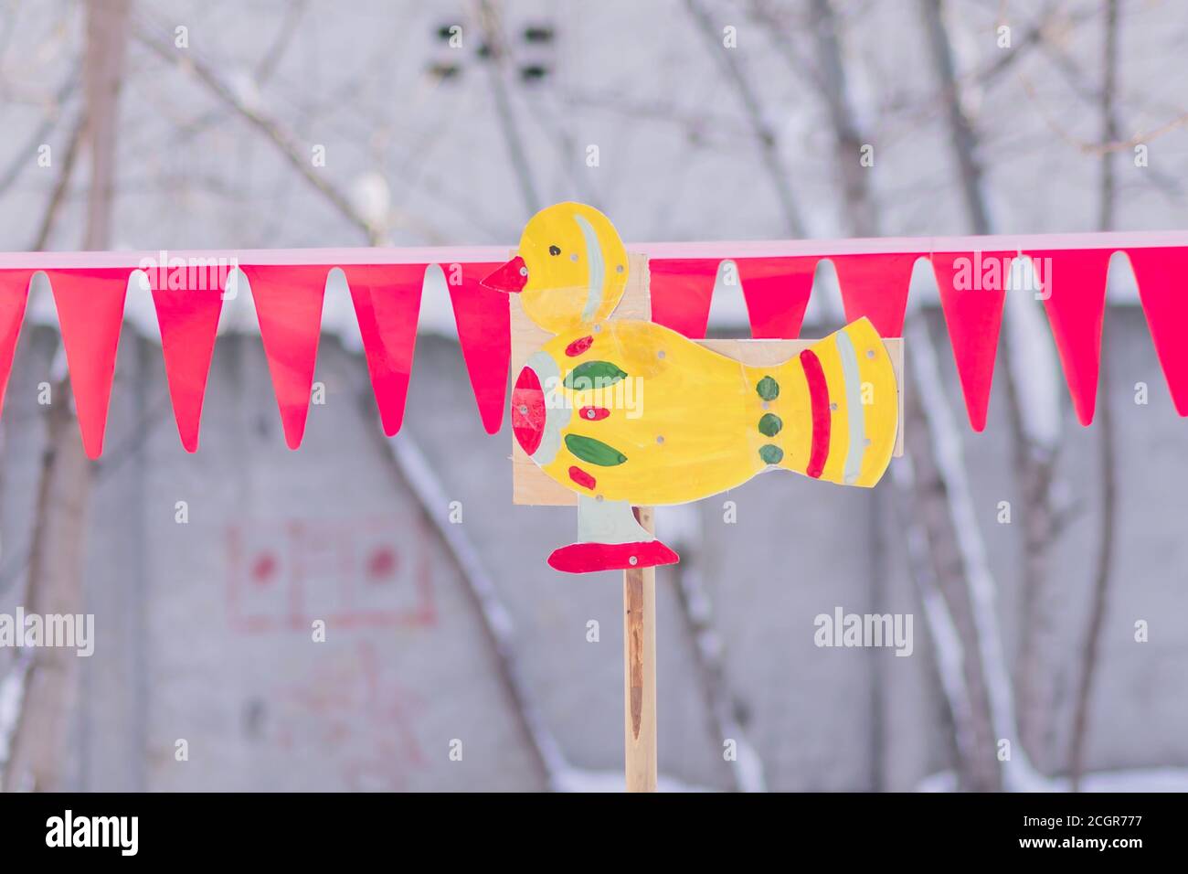 Children toy - wooden painted duck on a stick outdoors. Backyard decoration. Stock Photo
