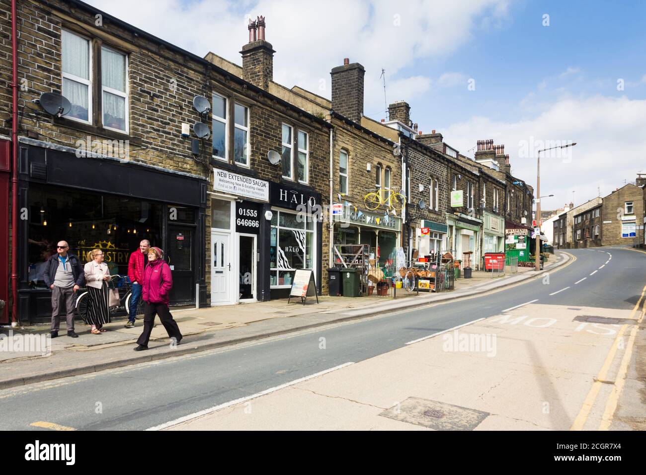 Local shops on Mill Hey, part of the B6412 in Haworth, West Yorkshire, looking towards Keighley from the railway station. Stock Photo