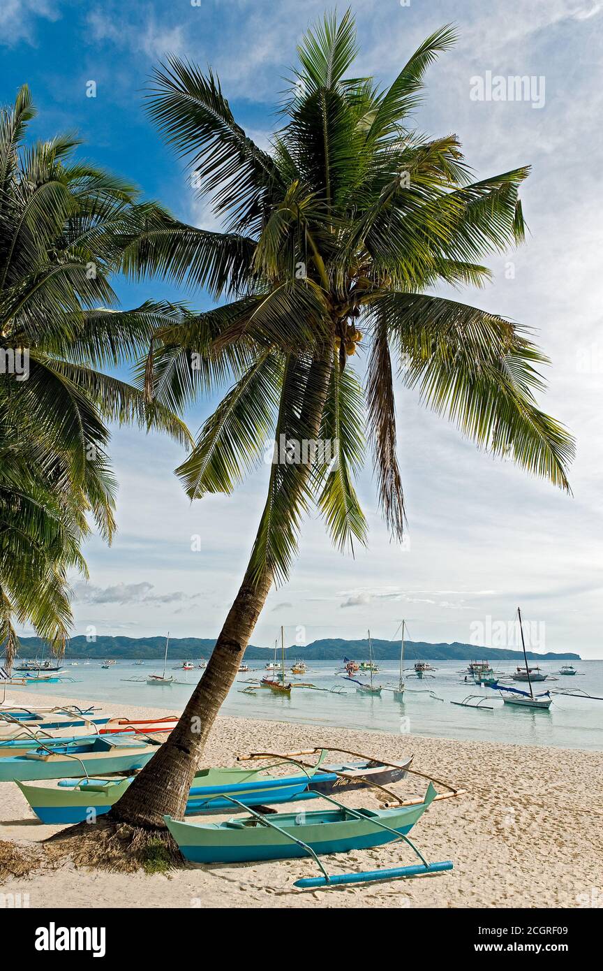 Scenic view of palm trees and many small fishing boats on the empty sandy White Beach on Boracay Island, Visayas, Philippines, Asia Stock Photo