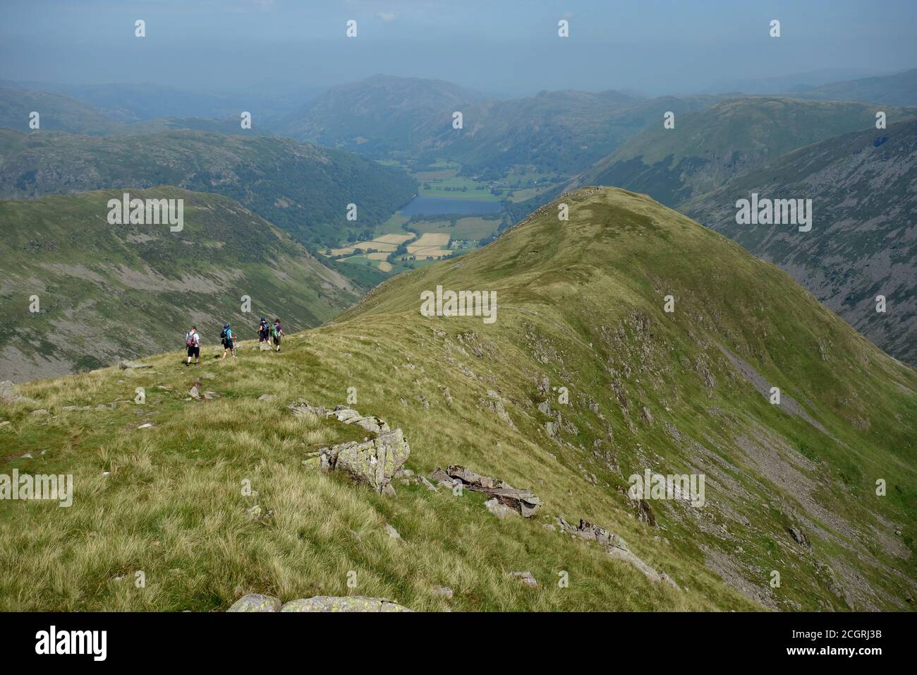 Four Fellwalkers on the Connecting Ridge to the Wainwright 'Middle Dodd' from 'Red Screes' in the Lake District National Park, Cumbria, England, UK. Stock Photo