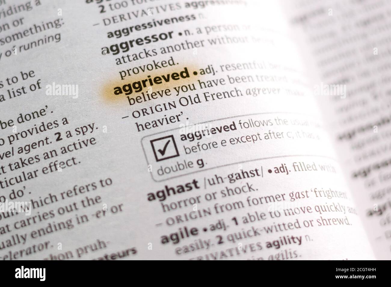 The word or phrase Aggrieved in a dictionary highlighted with marker ...