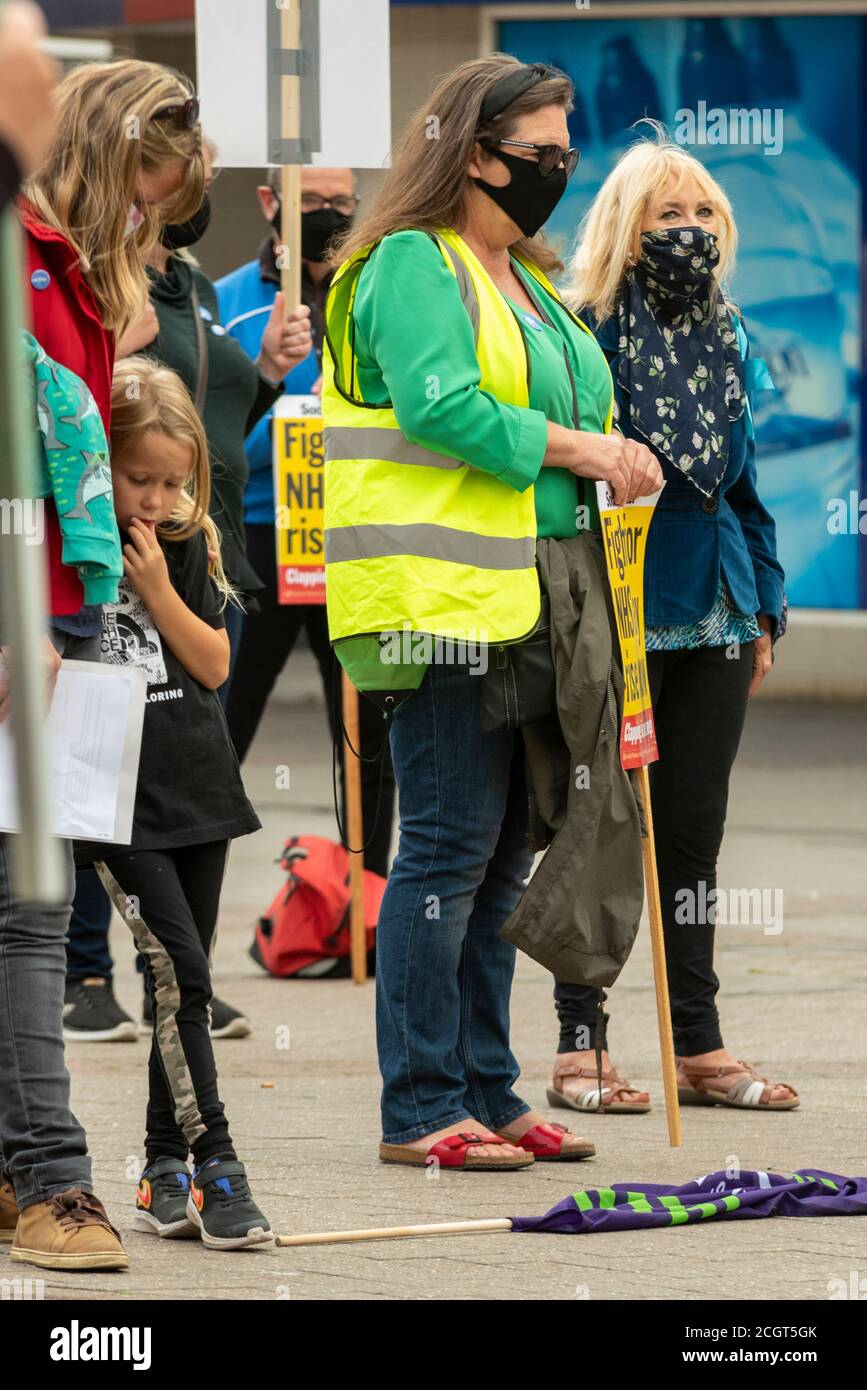 Minute's silence for care workers killed by COVID-19 Coronavirus by females at a protest against the lack of pay increase for NHS staff. Hugging child Stock Photo